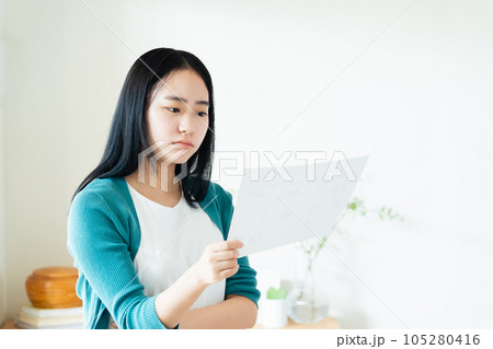 室内で書類を見る若い女性 105280416