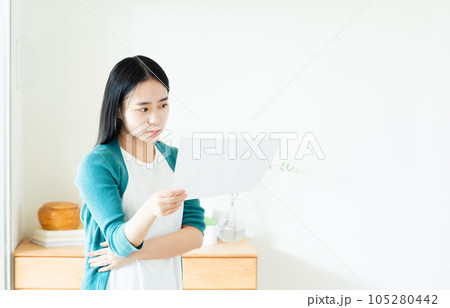 室内で書類を見る若い女性 105280442