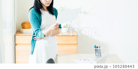 室内で書類を見る若い女性 105280443