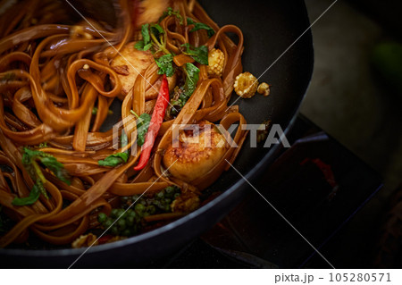 Stir frying Spicy pasta with Scallop in wok 105280571