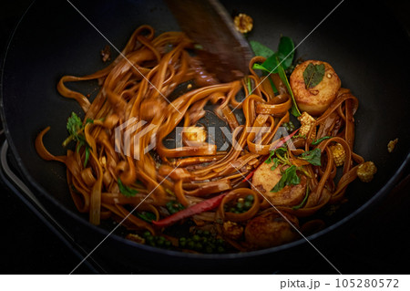 Stir frying Spicy pasta with Scallop in wok 105280572