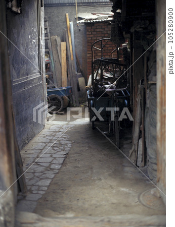 北京の古い町並み 胡同 民家の敷地に置かれた三輪自転車と生活道具 105280900