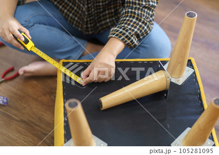 Asian Woman self repairs furniture renovation using equipment to diy repairing furniture sitting on the floor at home Asian Woman self repairs furniture renovation using equipment to diy repairing furniture sitting on the floor at home 105281095