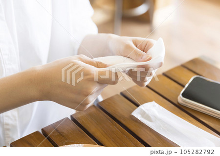 カフェで紙おしぼりで手を拭く若い女性 105282792