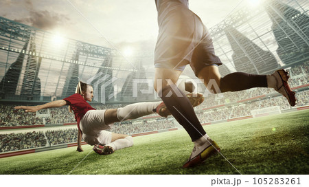 Dynamic image of female football players in motion during match, game. Woman hitting ball and falling down. 3d arena, blurred audience Dynamic image of female football players in motion during match, game. Woman hitting ball and falling down. 3d arena, blurred audience 105283261
