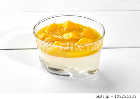 Vanilla panna cotta with mango puree and fresh fruits in glass Vanilla panna cotta with mango puree and fresh fruits in glass 105285335