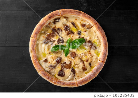 Pizza with cheese sauce, forest mushrooms and champignons garnished with basil 105285435