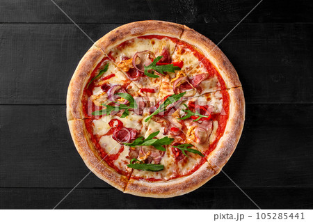 Pizza with sous vide chicken, bacon, salami, spicy pepper, onion and arugula 105285441