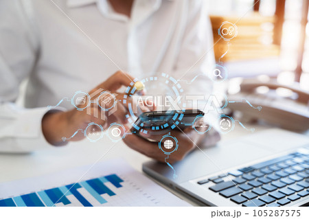 Agile development methodology concept. Business hand using laptop computer and tablet with virtual screen agile icon on modern office digital technology concept. 105287575