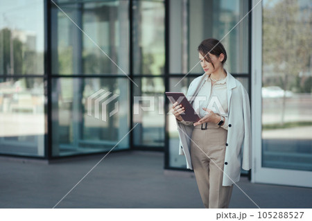 Portrait of a caucasian successful business woman used digital tablet in front of modern office building 105288527