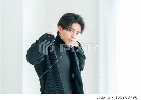 リビングの窓際でおしゃれをする若い男性 リビングの窓際でおしゃれをする若い男性 105288790