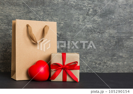 Shopping bag with gift box on colored background perspecrive view. Space for text holiday concept 105290154