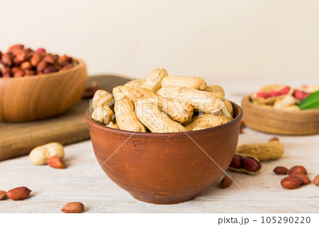 Fresh healthy peanuts in bowl on colored table background. Top view Healthy eating bertholletia concept. Super foods Fresh healthy peanuts in bowl on colored table background. Top view Healthy eating bertholletia concept. Super foods 105290220