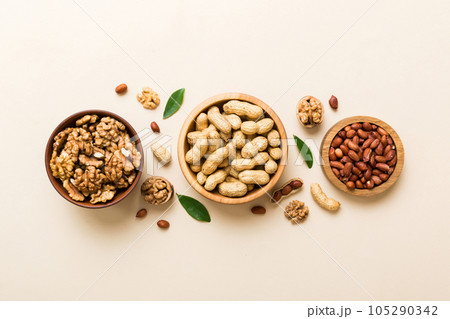 Walnut kernel halves, in a wooden bowl. Close-up, from above on colored background. Healthy eating Walnut concept. Super foods with copy space Walnut kernel halves, in a wooden bowl. Close-up, from above on colored background. Healthy eating Walnut concept. Super foods with copy space 105290342
