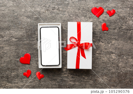 Opened gift box with ribbon and phone on color background, top view. Blank open box packaging mockup , Template for your design - branding mockup Opened gift box with ribbon and phone on color background, top view. Blank open box packaging mockup , Template for your design - branding mockup 105290376