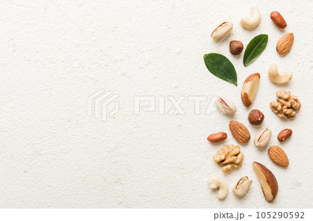 Composition of nuts , flat lay - mix hazelnuts, cashews, almonds on table background. healthy eating concepts and food background 105290592