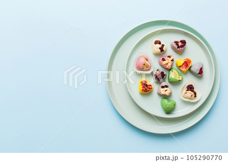 Plate with different chocolate on colored background. Assortment of fine chocolates top view vith copy space Health and obesity concept 105290770