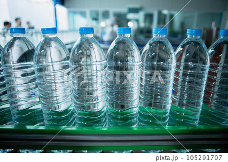 Drinking water plant. Selective focus water bottles on production line of factory.. 105291707