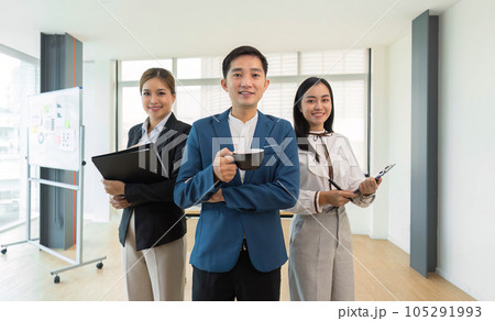 A portrait of happy and successful businesspeople standing in meeting room the looking to the camera, for teamwork business A portrait of happy and successful businesspeople standing in meeting room the looking to the camera, for teamwork business 105291993