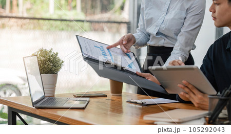 Two Asian businessmen met in the office and pointed to analysis charts and graphs of business growth and financial performance Two Asian businessmen met in the office and pointed to analysis charts and graphs of business growth and financial performance 105292043