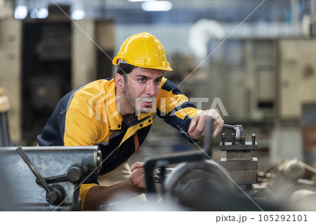Caucasian man engineering workers wear yellow hard hat working machine lathe metal. 105292101