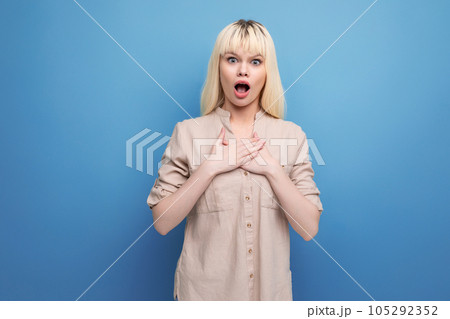 shocked puzzled blond young woman holding her heart shocked puzzled blond young woman holding her heart 105292352