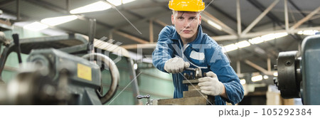 Male workers wear yellow hard hat holding wrench working on repairing factory machinery. 105292384