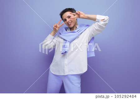 smiling young woman with short haircut in white shirt and blue pants 105292484