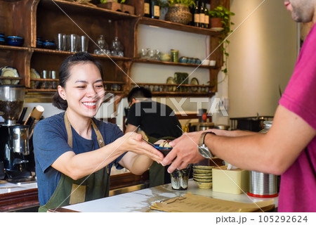 Vietnamese waitress serving ice cream for a customer in a coffee shop Vietnamese waitress serving ice cream for a customer in a coffee shop 105292624