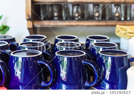 Many blue cups in a row on the woden shelf in the kitchen 105292627