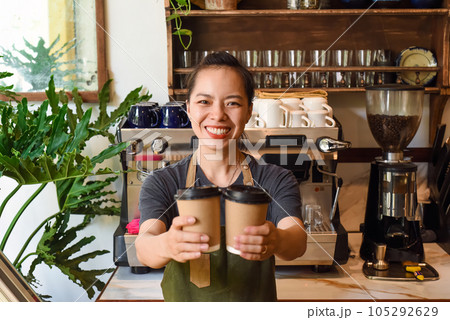 Vietnamese smiling waitress holding paper cups with coffee in a cafe 105292629