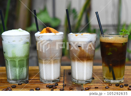 Coffee beverages with coffee beans on wooden table in a coffee shop Coffee beverages with coffee beans on wooden table in a coffee shop 105292635