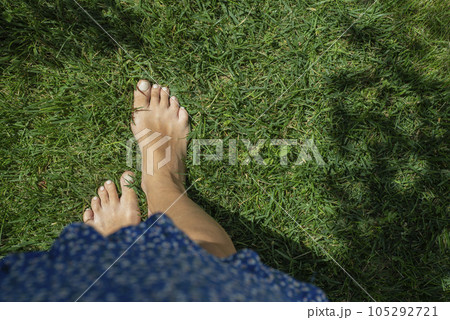 Close up female legs walking on the grass 105292721