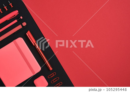 Red stationery set of pencil, pen, marker, clips, notebook, eraser on black and red backdrop. Space for your text Red stationery set of pencil, pen, marker, clips, notebook, eraser on black and red backdrop. Space for your text 105295448