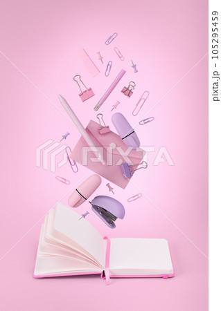 Pink and lilac stationery flying in the air against notebook. Pink background. 105295459