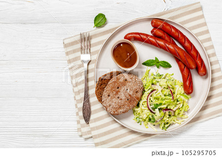 sausages with coleslaw salad, bbq sauce on plate sausages with coleslaw salad, bbq sauce on plate 105295705