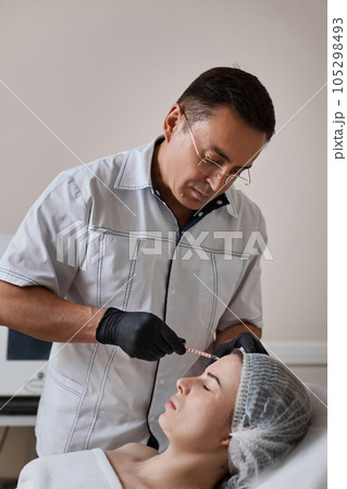 woman receives cosmetic botox injection in face. woman receives cosmetic botox injection in face. 105298493