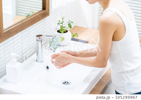 洗面台で手を洗う女性。 105299967