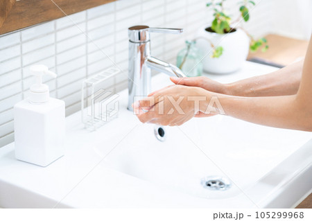 洗面台で手を洗う女性。 105299968