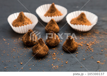 Sugar scrubs in the form of truffles in separate portion substrates for sweets on a black background Sugar scrubs in the form of truffles in separate portion substrates for sweets on a black background 105300137