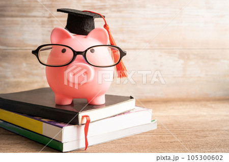 Pigging bank wearing eyeglass with with coins and calculator; saving bank education concept. Pigging bank wearing eyeglass with with coins and calculator; saving bank education concept. 105300602
