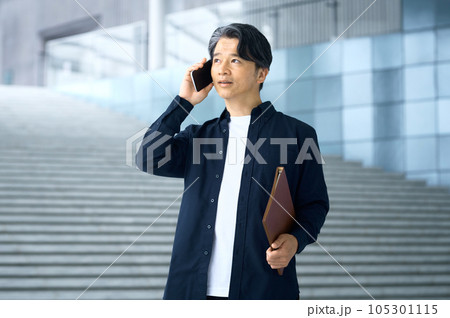 オフィスで電話する私服のビジネスマン オフィスで電話する私服のビジネスマン 105301115