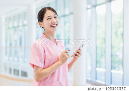 スマホを操作する医療従事者の女性 105301577