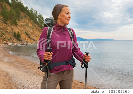 Hiking tourism adventure. Backpacker hiker woman looking at beautiful view. Hiker girl lady tourist with backpack walking near lake. Young happy woman enjoy hike trekking tourism active vacation 105303169