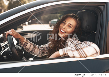 Young smiling woman driving a car in the city 105303463