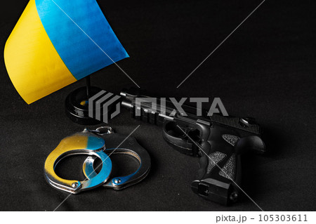 Ukrainian flag and handcuffs on black background, concept of crime and justice in the country 105303611