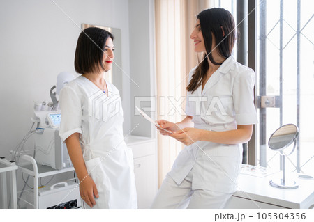 Two female doctors standing in medical clinic, 105304356