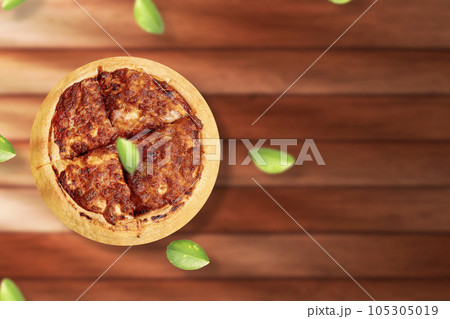 Margherita pizza on wooden table background. Fly lemon green leaf. Top view with copy space Margherita pizza on wooden table background. Fly lemon green leaf. Top view with copy space 105305019