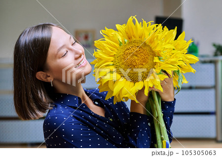 Young happy woman with bouquet of yellow sunflower 105305063