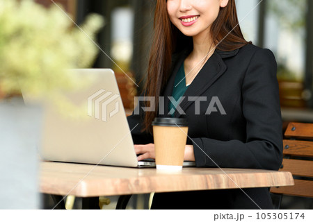 屋外でPCを操作する若いアジア人の女性 屋外でPCを操作する若いアジア人の女性 105305174
